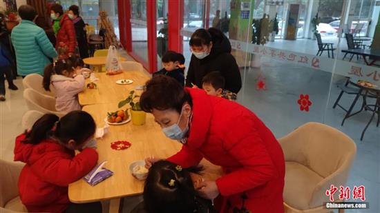 “共享奶奶”带着孩子们吃饺子。陈选斌 摄